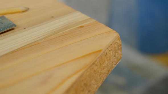 Surfboard with pencil and scale in workshop