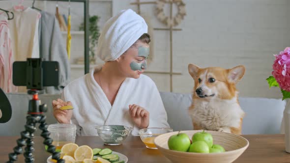 A Girl With a White Towel Put on Her Face a Green Mask During Blogging