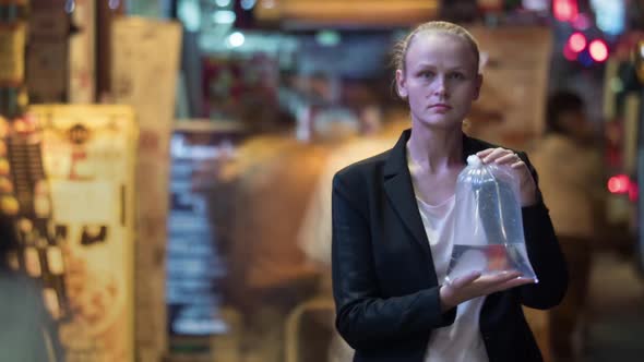 Timelapse of Woman with Fish in Plastic Bag Among the Crowd