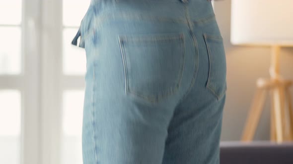 Woman Pulls Her Jeans Over Her Buttocks. Cellulite Is Visible on the Skin