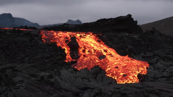Stunning Icelandic landscape with volcanoes and lava flowing through black rocks