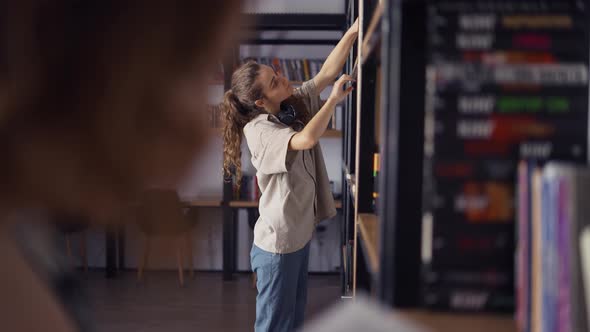 Young College Students in an University Library Looking for Books