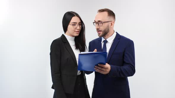 Smiling Male and Female Colleagues Communicating Holding Folder