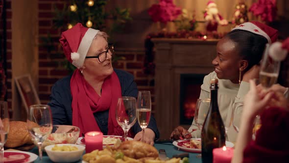 Senior Woman Talking with Festive Young Adult Person While Enjoying Christmas Dinner at Home