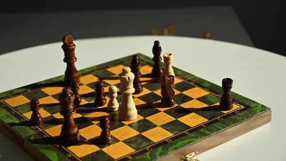 A Man Drops a King on a Spinning Chessboard