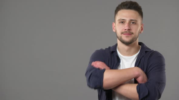 Portrait of Young Handsome Man Wearing Basic Clothing Appearing at Camera at Posing with Arms