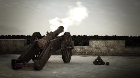 Old-fashioned heavy Cannon Defending Fort firing a bronze ball with a smoke.