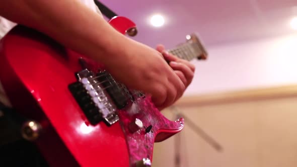Close-up of Male Guitarist Hands Playing on Red Electric Guitar