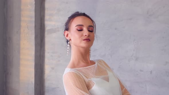 A Girl in a White Dress Professionally Poses for a Photographer Closeup