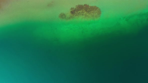 Top down aerial shot, flying towards the coast of the Tegernsee with crystal clear water.