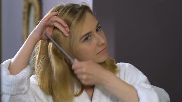 Pretty Female Combing Hair in Front of Mirror and Smiling, Morning Beauty Ritual