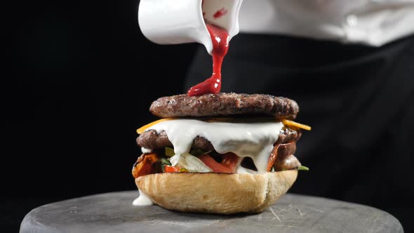 Chef Preparing Juicy Burger and Pours Spicy Sauce on It Making Burgers at Fast Food Restaurant, Slow