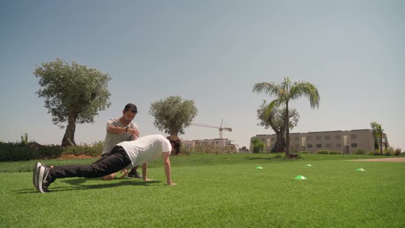 Middleaged Coach at Training in the Park with a Young Man