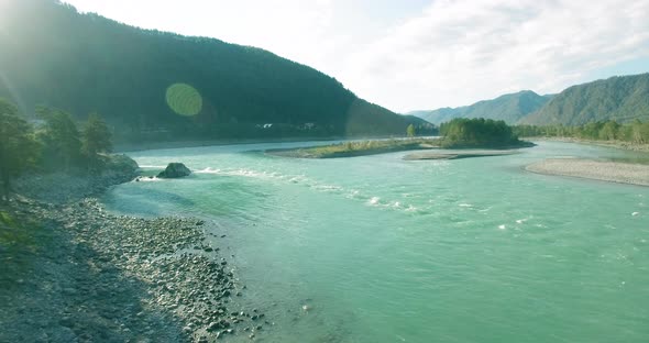 Low Altitude Flight Over Fresh Fast Mountain River with Rocks at Sunny Summer Morning.