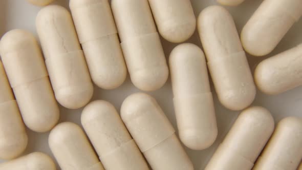 Rotation macro White beige capsule pills, tablets, top view