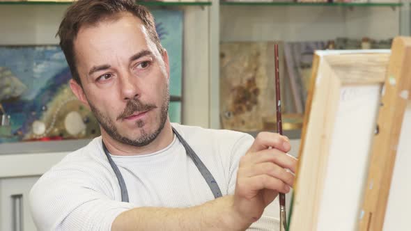 Professional Artist Concentrating Over His Painting