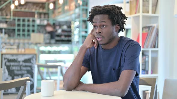 Pensive African Man Thinking in Cafe