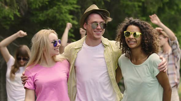 Happy Young Man Dancing With Two Beautiful Women at Outdoor Party, Summer Flirt