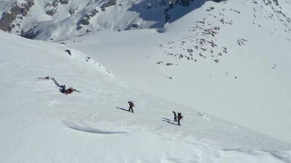 Aerial lowering of a group of hikers climbing to the peak of a snowy Piltriquitron Hill, El Bolsón,