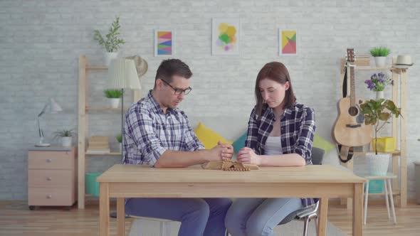 Young Couple Reads a Prayer in a Modern Apartment