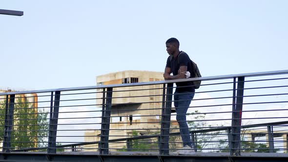 solitude, sadness - black student on the bridge looks into the distance