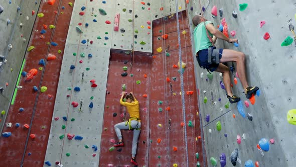 Man and woman practicing rock climbing in fitness studio 4k