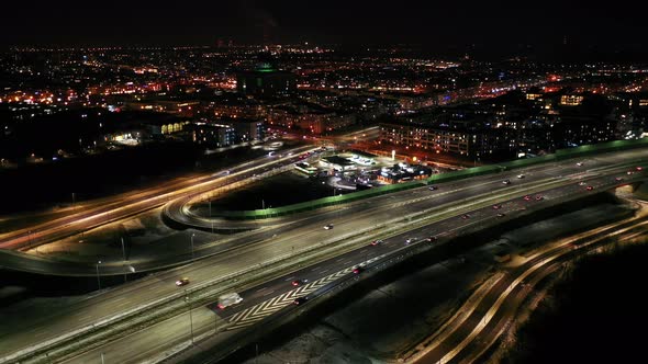 Top down night city roads with cars driving aerial view. Nightly urban cityscape with modern skyscra