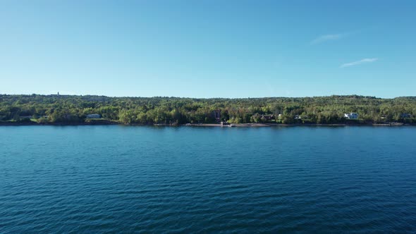 Drone aerial view zooming in on the Lake Superior shoreline in fall