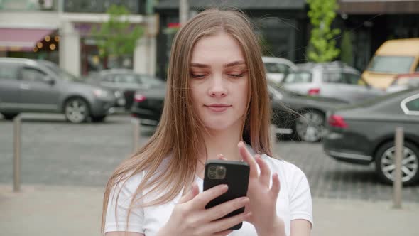 Attractive Young Woman Using Smartphone Outdoors