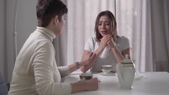 Young Brunette Caucasian Girl Crying and Complaining Mom About Her Problems. Mother Calming Down Her