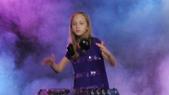 Teenage Girl in Headphones Plays for Dj Console. Smoky Background