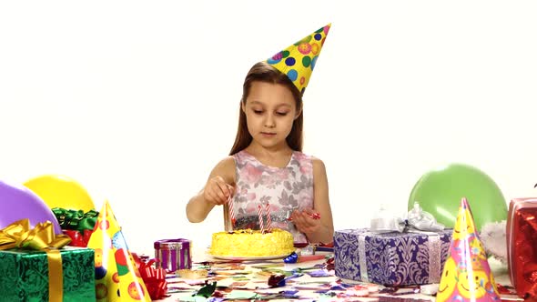 Beautiful Girl Decorates a Cake with Candles