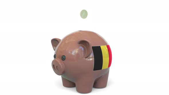 Putting Money Into Piggy Bank with Flag of Belgium alt