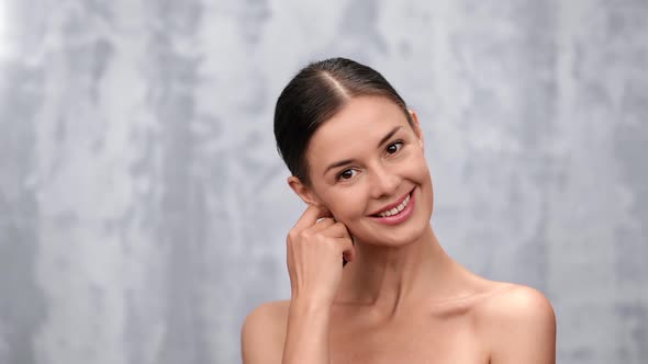 Adorable Smiling Woman Stroking Skin of Chin Posing Isolated