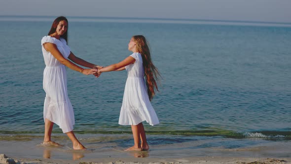Mom and Daughter are Walking Near the Sea