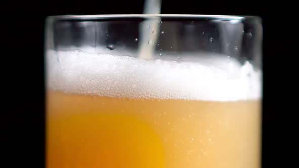 Extreme Closeup Pouring Stream of Craft Golden Beer Into Transparent Glass Slowmo
