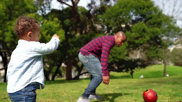 Little African American Boy Running and Kicking Ball