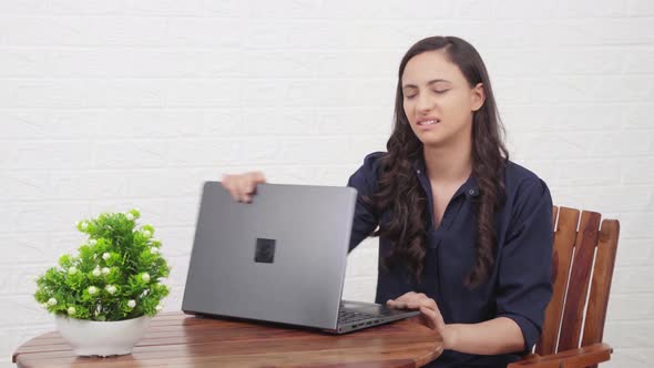 Frustrated Indian girl working on a laptop