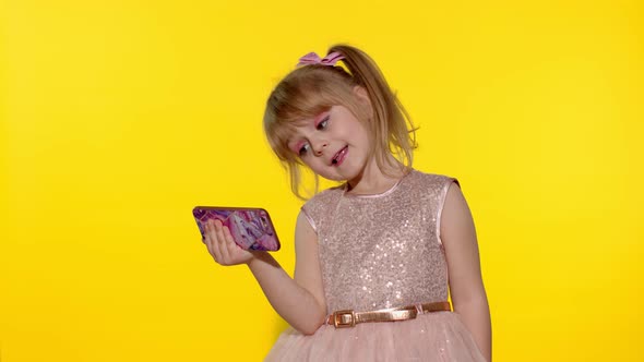 Child Girl Using Smartphone. Kid Looking at the Screen of a Mobile Phone, Watching Cartoons