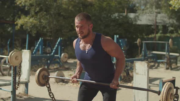 Bodybuilder Doing Deadlift Exercise at Outdoor Gym