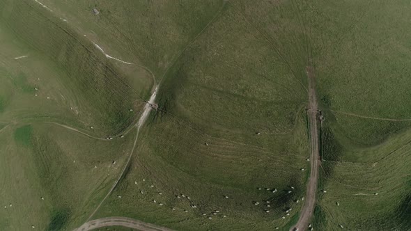 Aerial tracking backwards from the top of Maiden castle across the western gate ramparts. Lots of sh