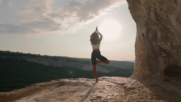 Athletic Woman Performs Spiritual Yoga Pose on Mountain Top Sunset