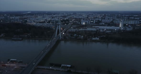 Slow Descending Wide Aerial shot of SNP Bridge and Petrzalka in Bratislava at twilight