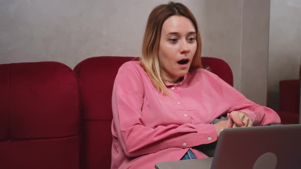 Emotional Young Caucasian Woman Looking at Laptop Screen Reading Email with Unexpected Amazing News