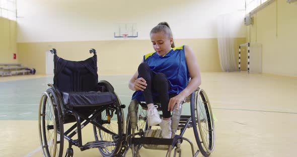 A Woman with Disabilities Basketball Player Prepares for a Match While Sitting in a Wheelchair