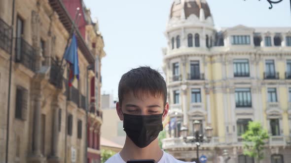 Tourist in a medical black mask in an old European city uses geolocation