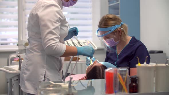 Female Dentist at Work with Assistant