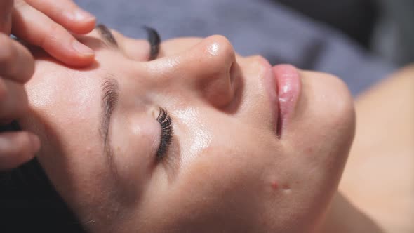 Young Woman in a Chic Beauty Salon Gets a Facial Massage and Beauty Treatments for Skin Care