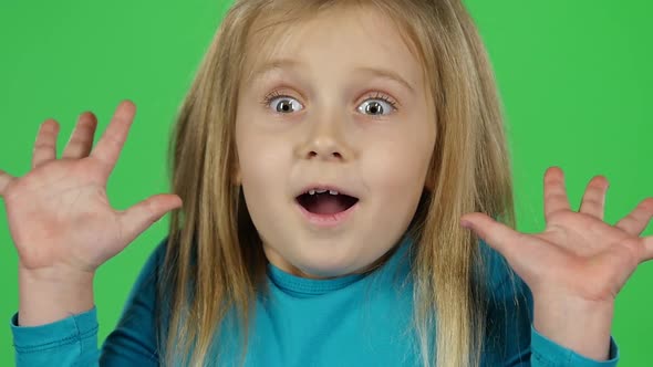 Close-up Child Posing Shows Frightened Emotion on Green Background. Slow Motion