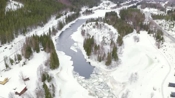 Icy Forest Landscape And Stream In Huagastol Norway - aerial shot